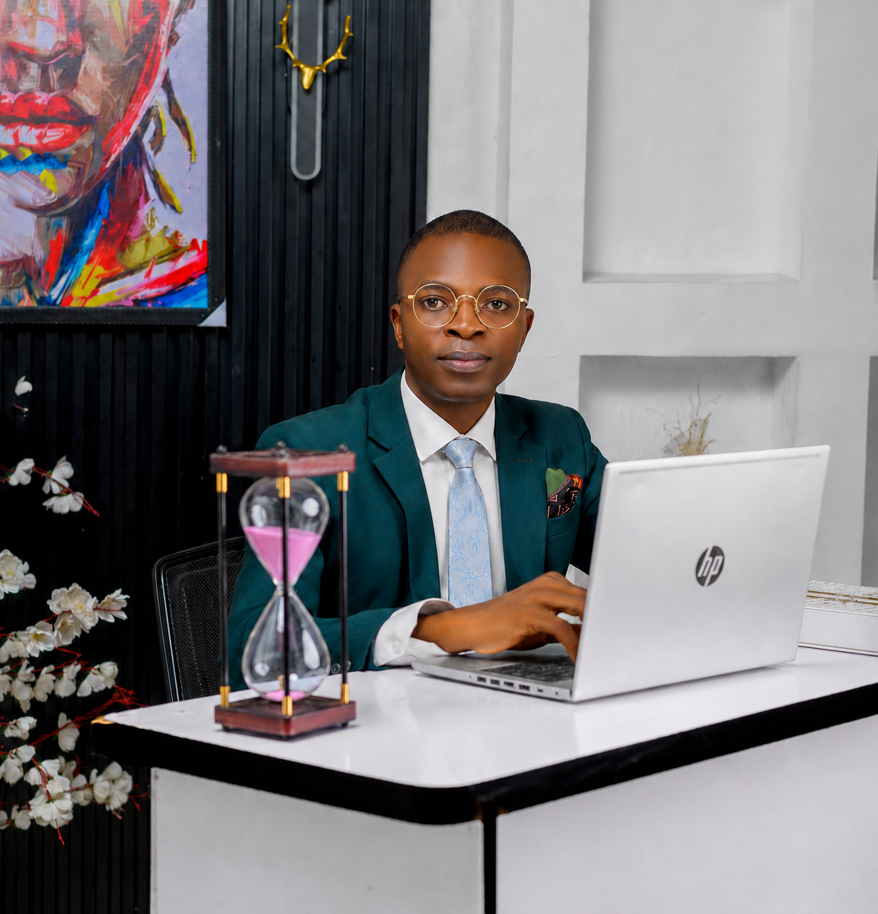 Pastor Folorunso Alesinloye wearing glasses at a laptop, representing wisdom-first AI and automation leadership